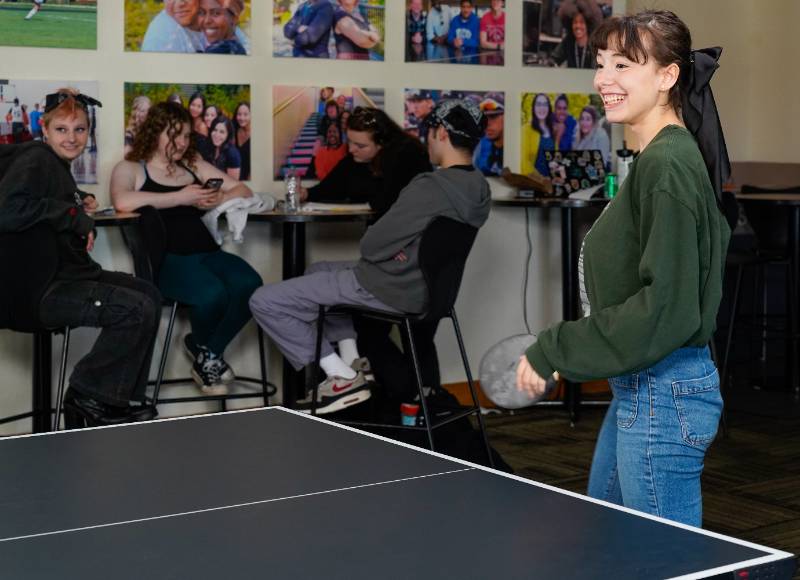a student plays ping pong in the student center