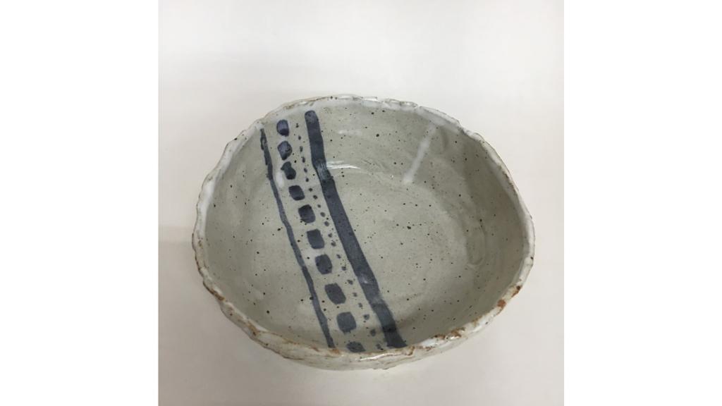 A tan bowl with a blue stripe through the center