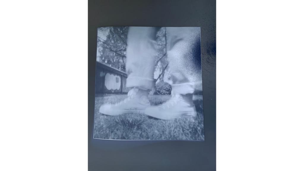 Black and white photo of boots in grass