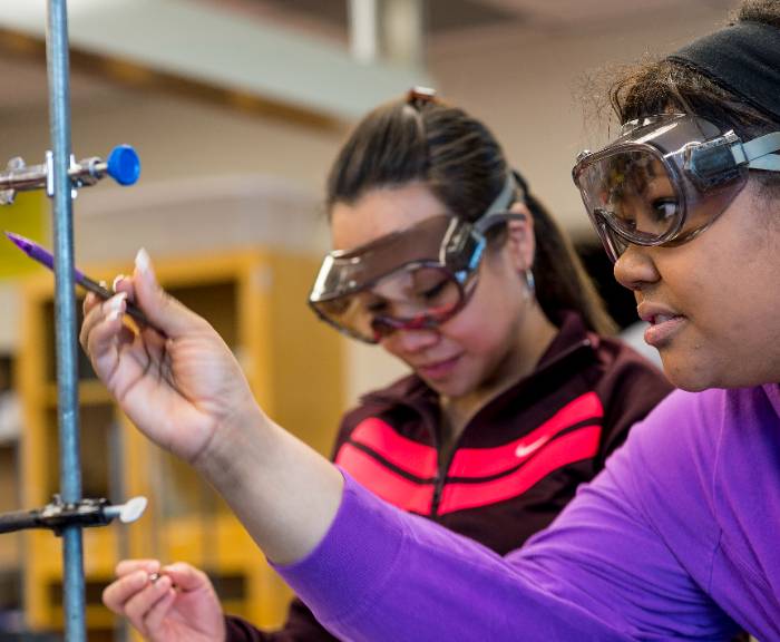 a woman wearing googles conducts an experiment