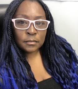Hedshot of Sabreehna Essien wearing white glasses and a black top