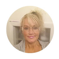 a headshot of an artist with dreads wearing a colorful vest