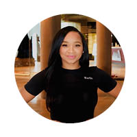female in black shirt standing with hands on hips