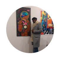 male standing next to art on wall