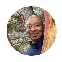 gentleman poking head out from behind a tree