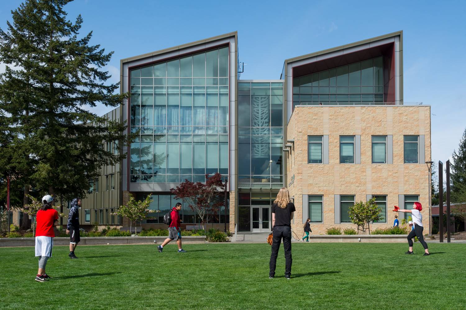 TCC students playing catch on a sunny day in the campus commons