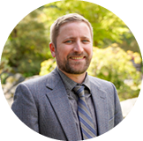 male in suit smiling