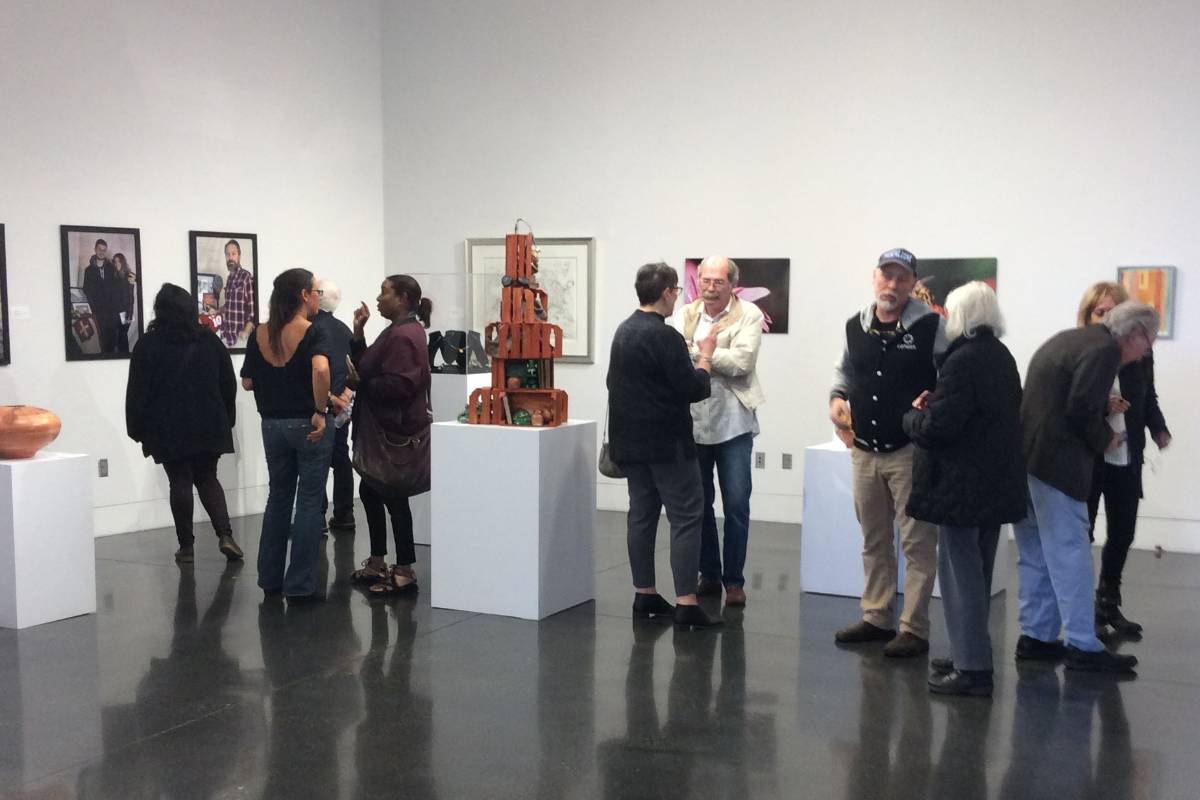 A group of people stand in the TCC art gallery