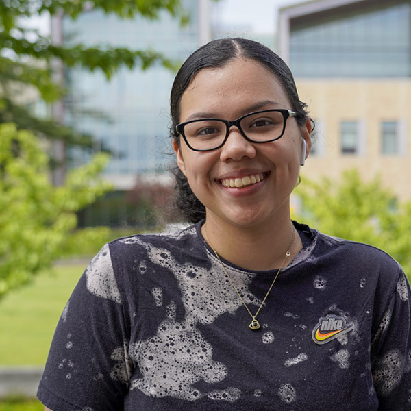 woman with black patterned shirt and glasses smiling 