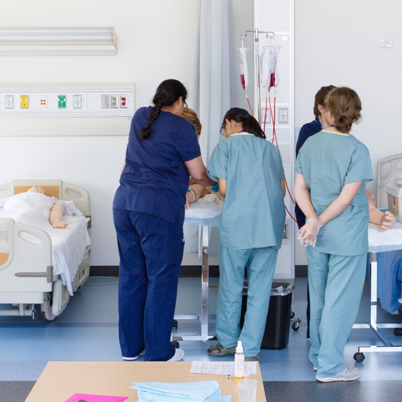 nursing students practicing blood draw with backs to camera