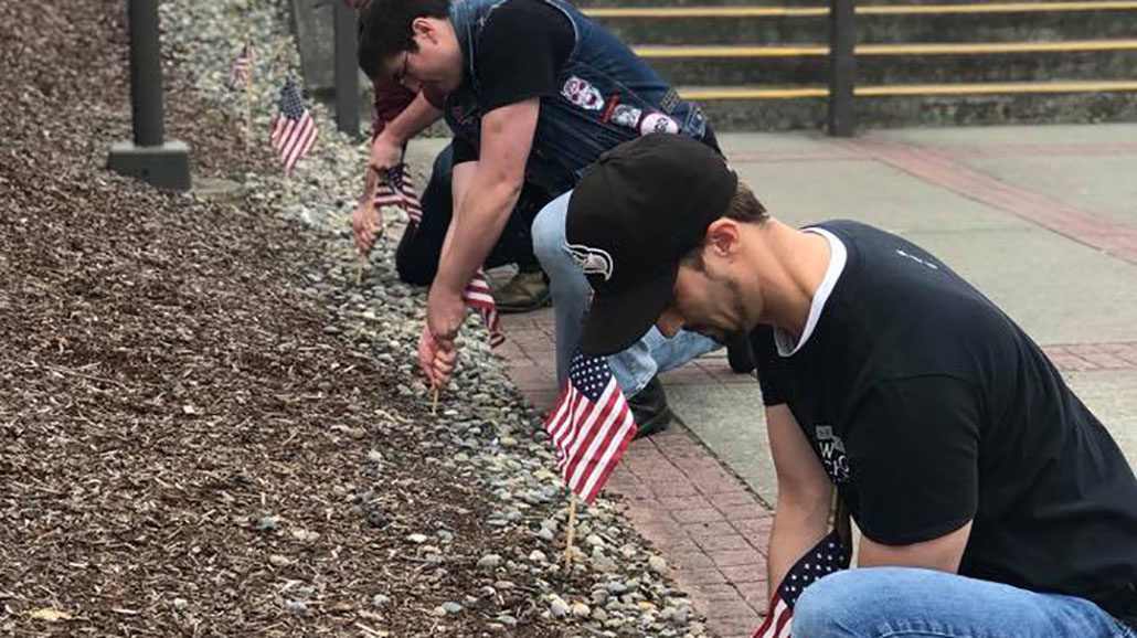 students placing ameriencan flags for veterans