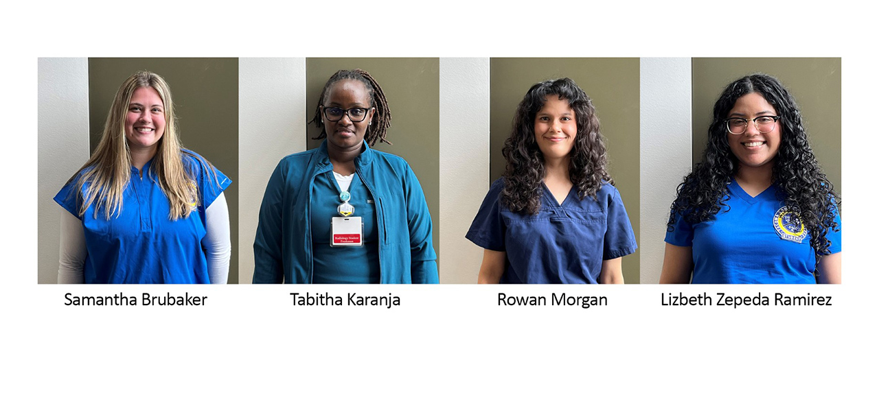 four women wearing scrubs smiling