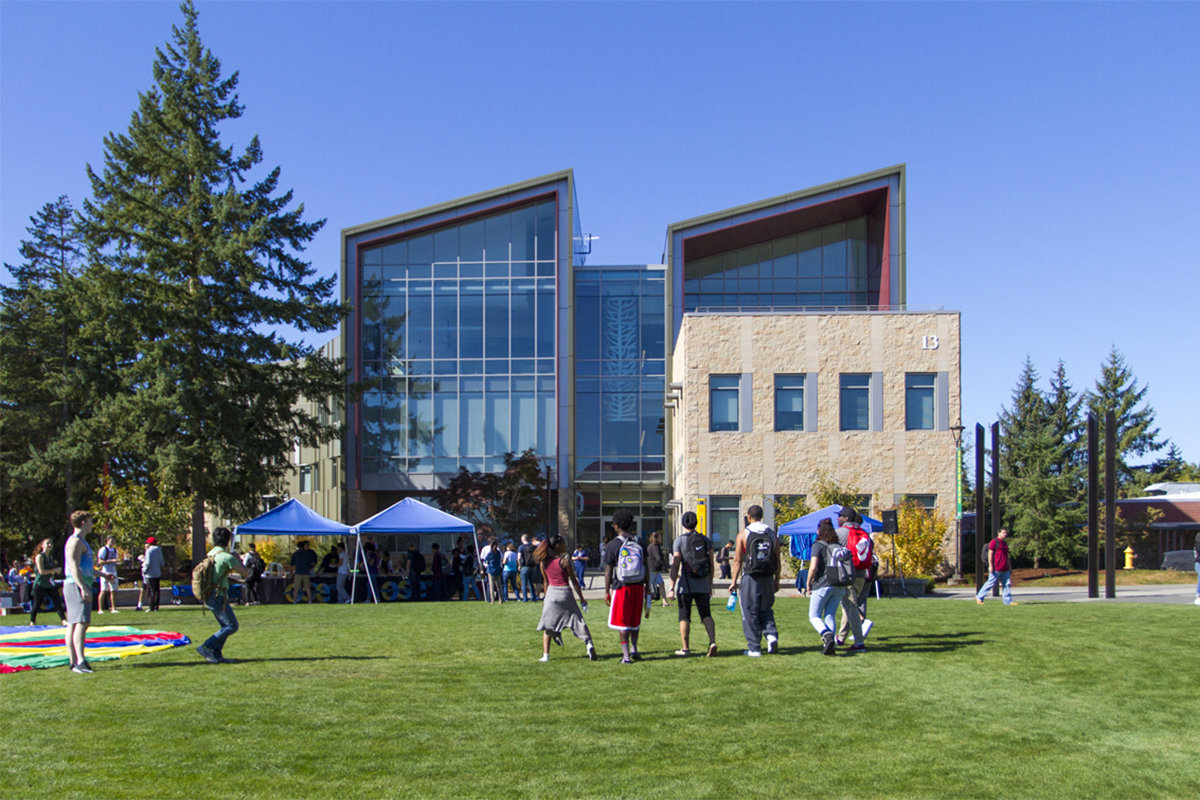 A group of students walking across the campus commons toward Building 13