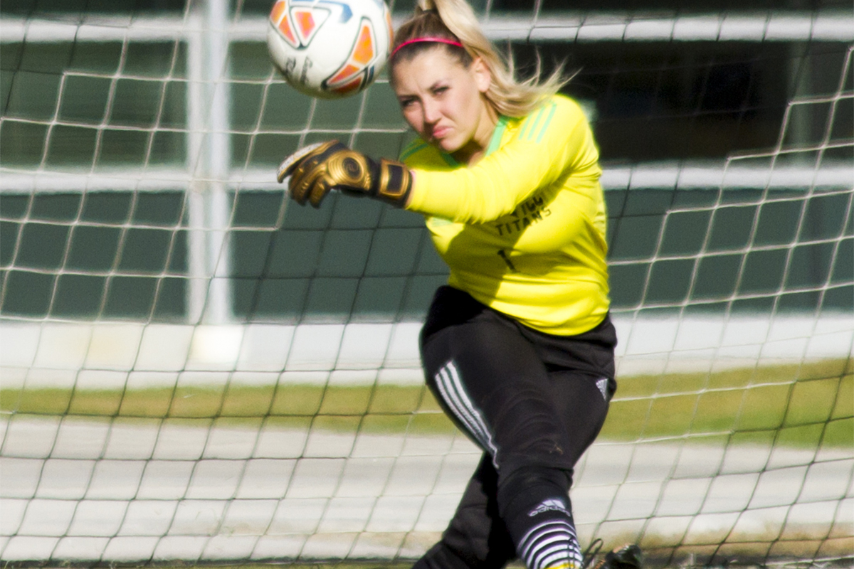 A female soccer player kicks a ball