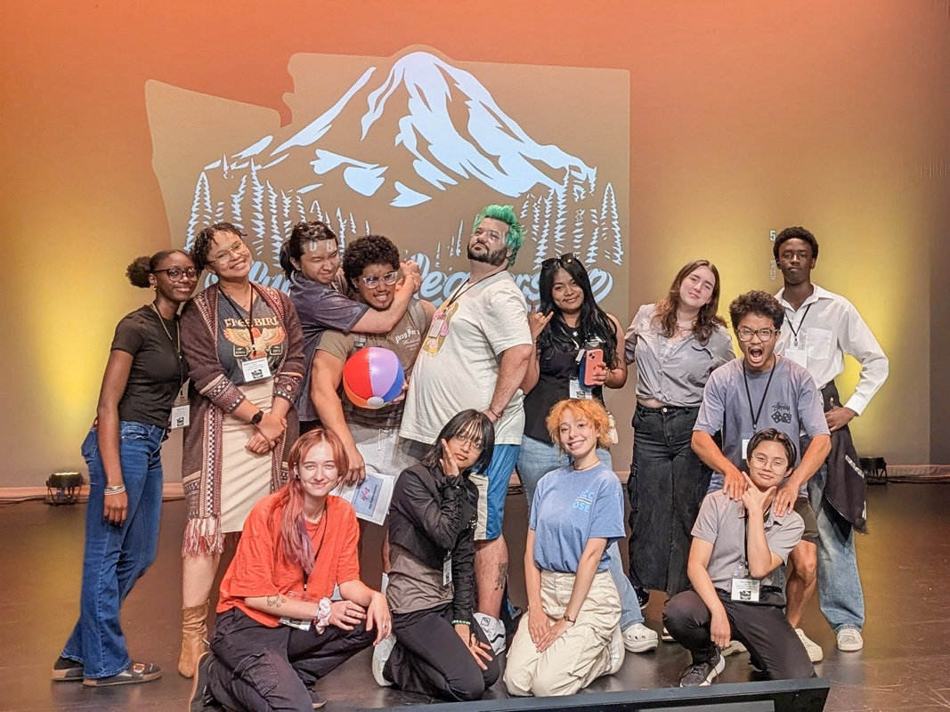 a large group of students under a drawing of Washington State. 
