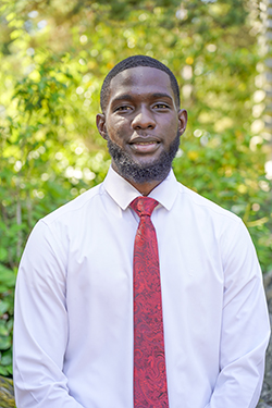 Man in a white shirt and red tie smiling