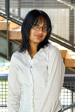 Image of a woman with short hair and glasses wearing a white shirt