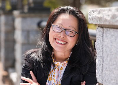 a woman with black hair smiling on the TCC Bridge