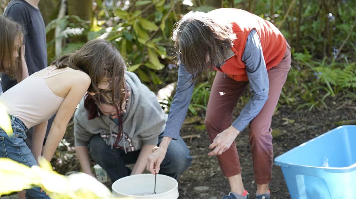 professor helping attendees prepare for the salmon release